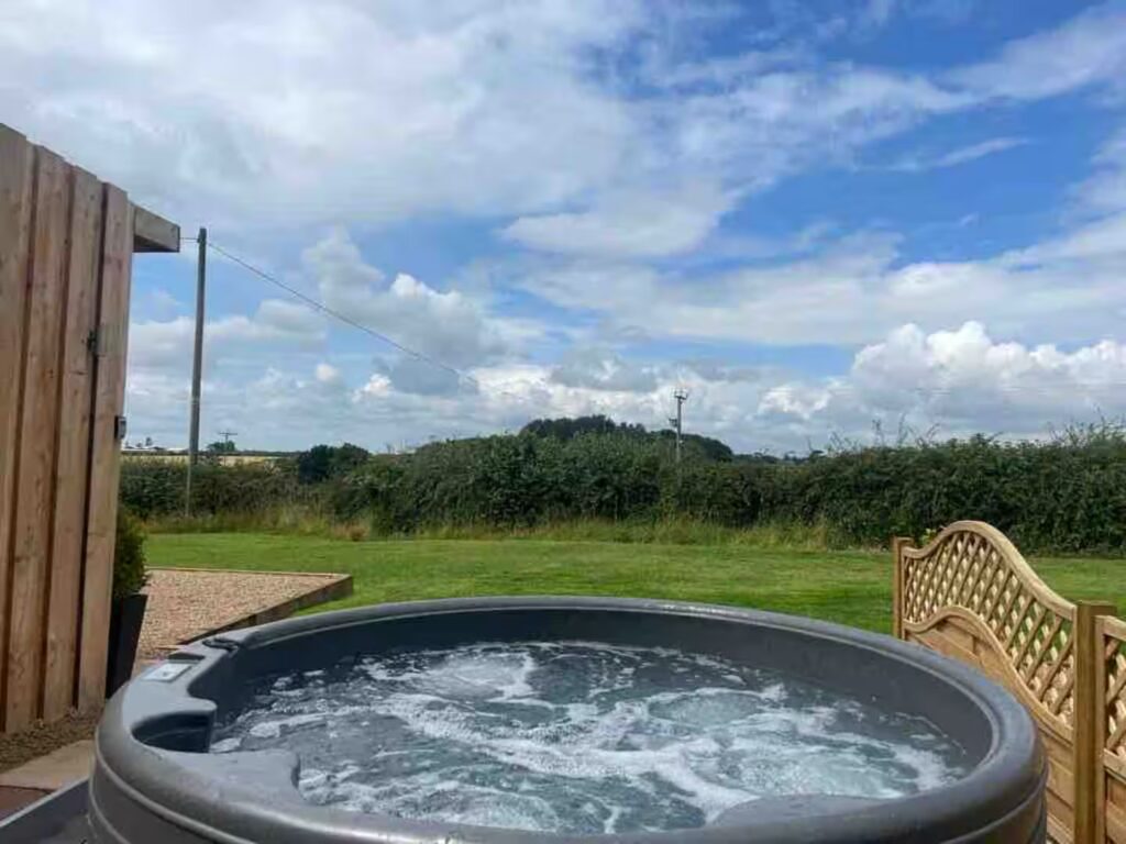 Private hot tub overlooking countryside – The Oaks Hut