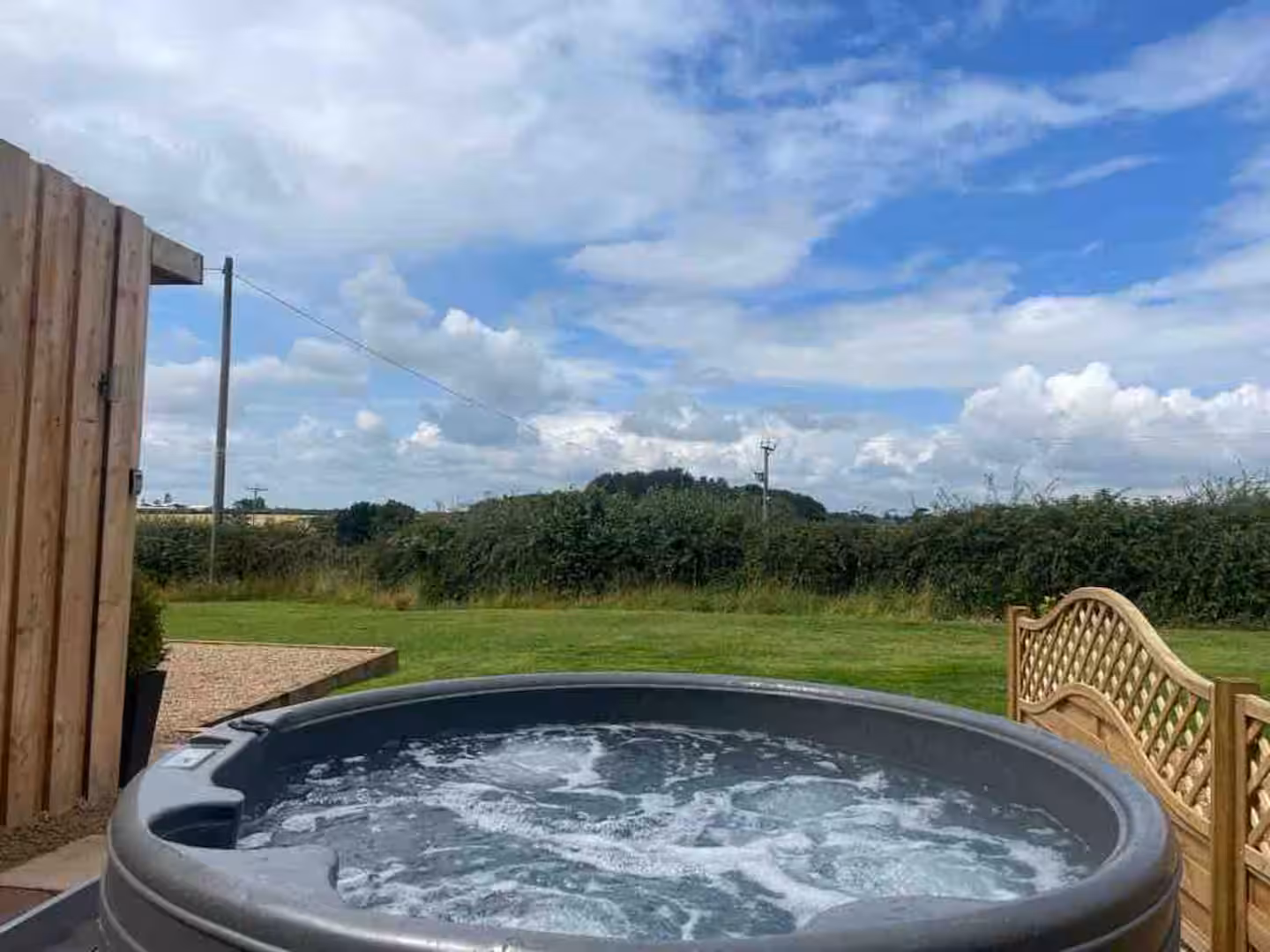 Private hot tub overlooking countryside – The Oaks Hut